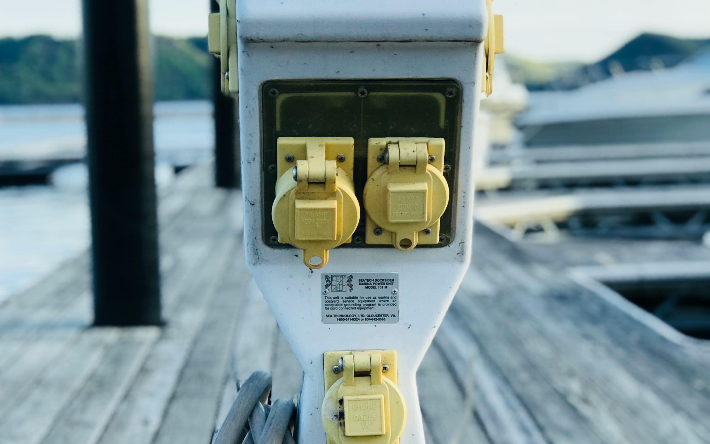 Dockside electrical hub near boats at a marina