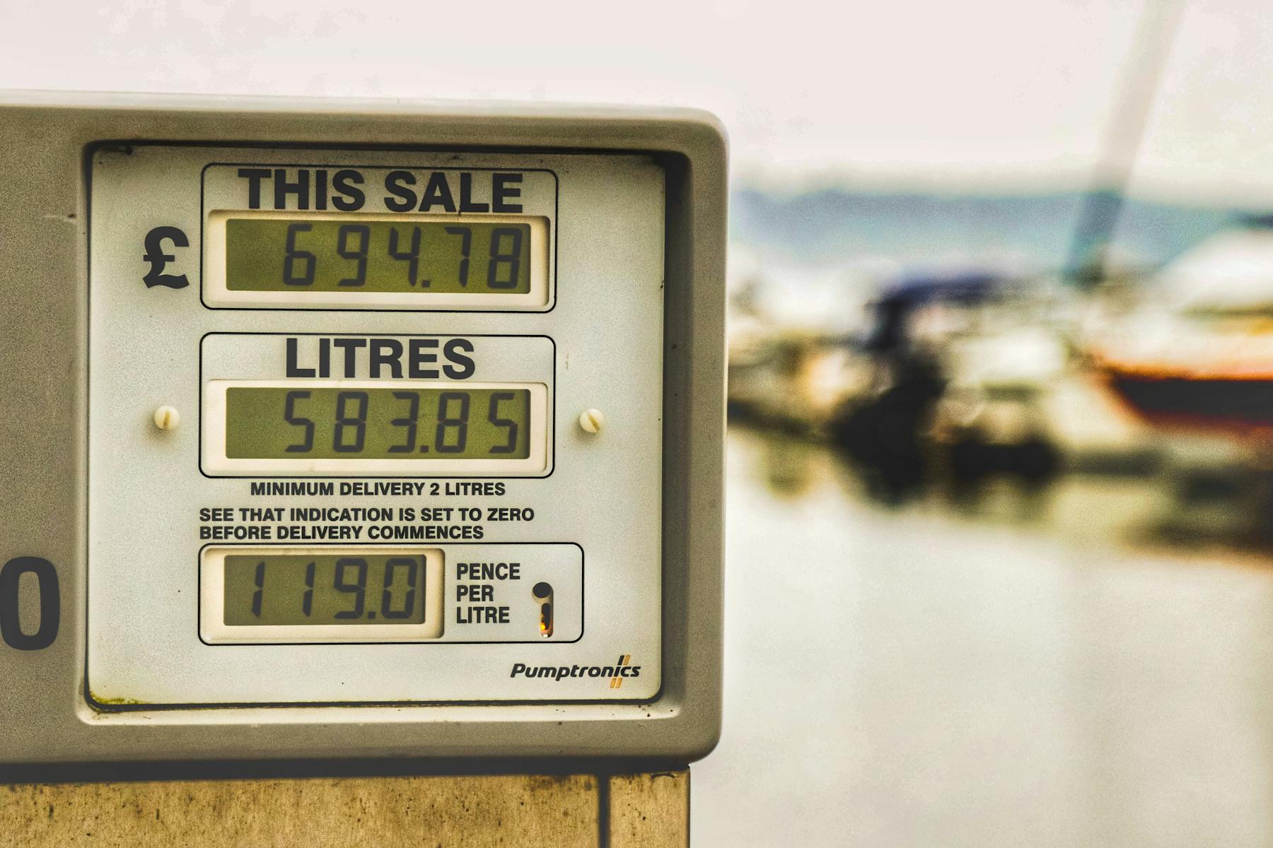 Fuel pump display at a marina fuel station with boats in the background