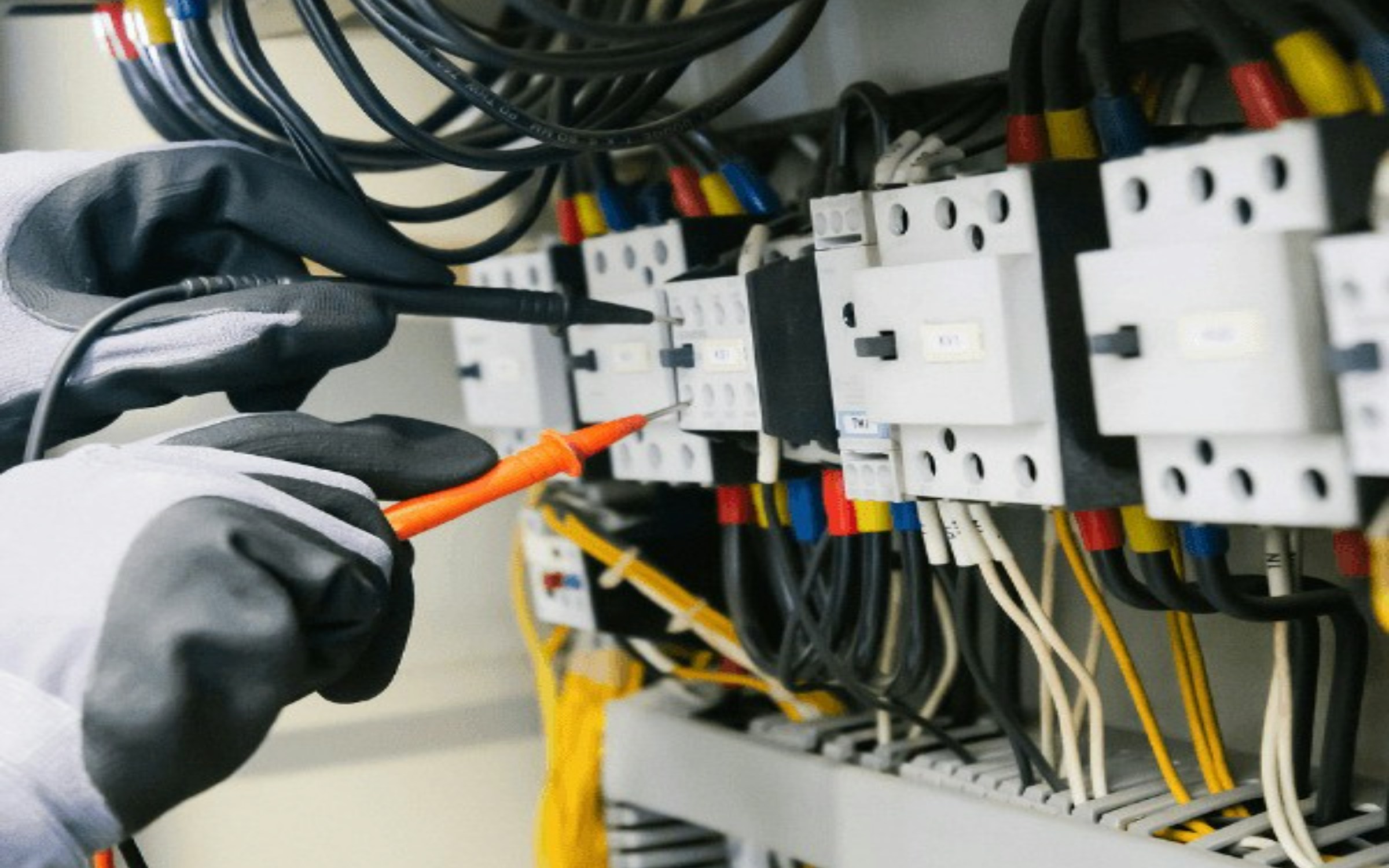Technician testing an electrical control panel